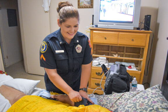 A paramedic administers a sleeve onto a patient bedside